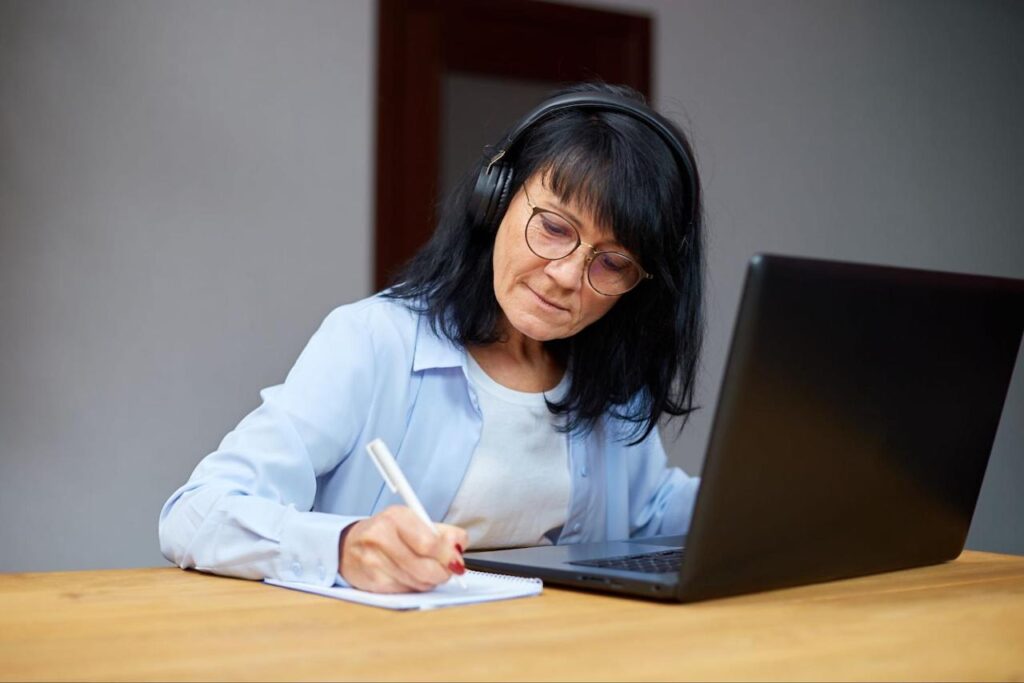 Employee taking notes while attending a virtual onboarding event.
